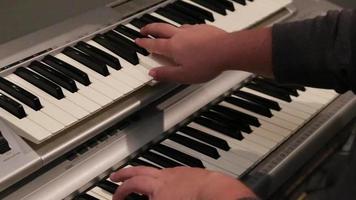 un músico toca un piano y un teclado