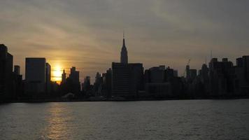 New York gebouwen afgetekend van water bij zonsondergang 4k video