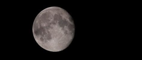 Nocturnal shot of full moon moving slowly in black background in 4K