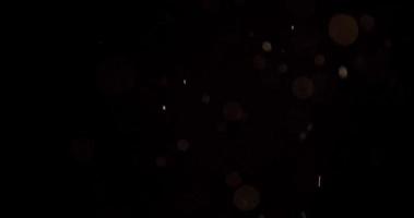 partículas suaves brillantes que caen a la esquina inferior derecha en la oscuridad en 4k video
