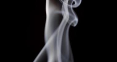 Focused and blurred focal planes of beautiful white smoke floating on dark background in 4K
