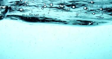 blauwe acuatische scène van belletjes textuur drijvend in helder water in 4k video