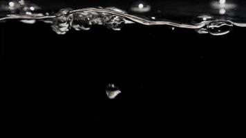 Shiny bubbles moving fast from lower to upper section and exploding in the surface with black background in 4K