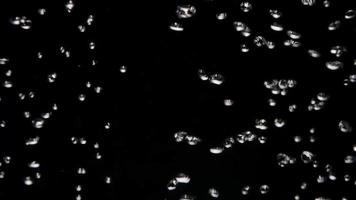 Turning on and off a machine bubbles of a water container creating a texture of bubbles on dark backgroun in 4K video