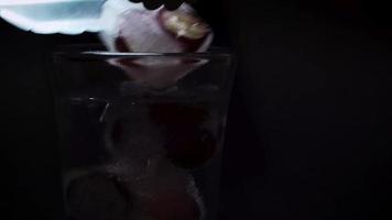 colocando un hielo con uvas en agua mineral video