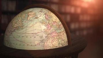 Spinning globe with ancient world map in old library video