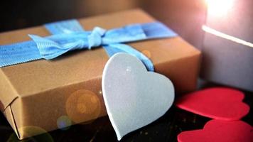 gift boxes with paper hearts on wood table close up video