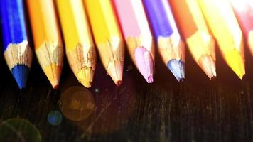 On a wooden background multi-colored pencils. Bright colored pencils Close up. Macro. Macro shooting video