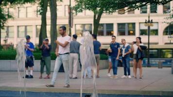 amis prenant des photos dans une fontaine dans un parc public video