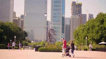 persone che camminano accanto a una scultura di tubi in grant park video