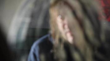 L'homme déprimé et en colère est assis devant son reflet dans une vieille maison abandonnée video