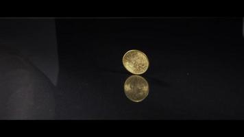 Moneda girando sobre una superficie reflectante - dinero 0045 video