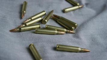 Cinematic rotating shot of bullets on a fabric surface - BULLETS 100 video