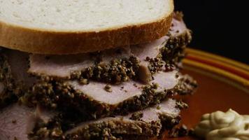 Rotating shot of delicious, premium pastrami sandwich next to a dollop of dijon mustard - FOOD 035