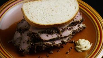 Tir rotatif de délicieux sandwich au pastrami de première qualité à côté d'une cuillerée de moutarde de Dijon - nourriture 045 video