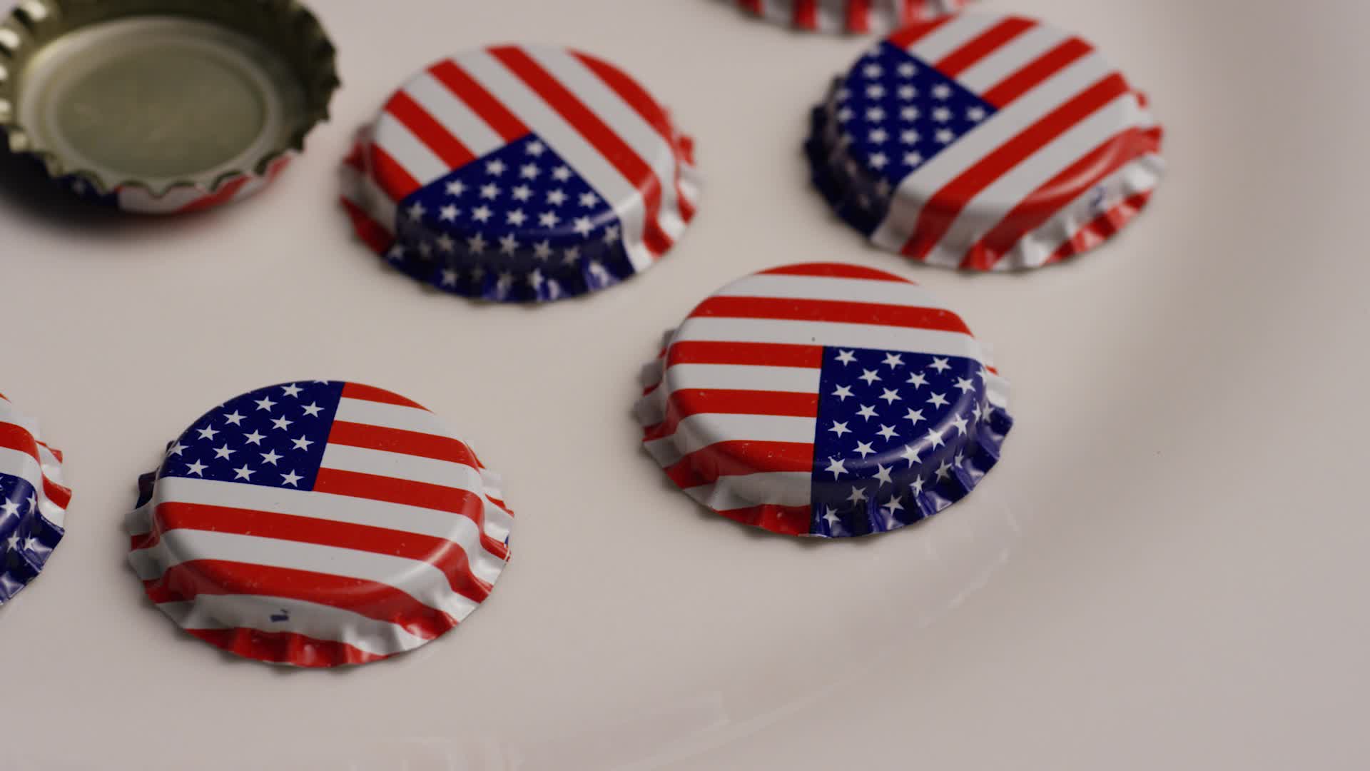 Rotating shot of bottle caps with the American flag printed on them