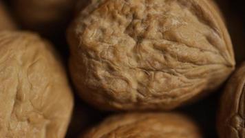 Cinematic, rotating shot of walnuts in their shells on a white surface - WALNUTS 066 video