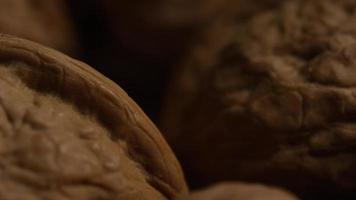 Cinematic, rotating shot of walnuts in their shells on a white surface - WALNUTS 020 video