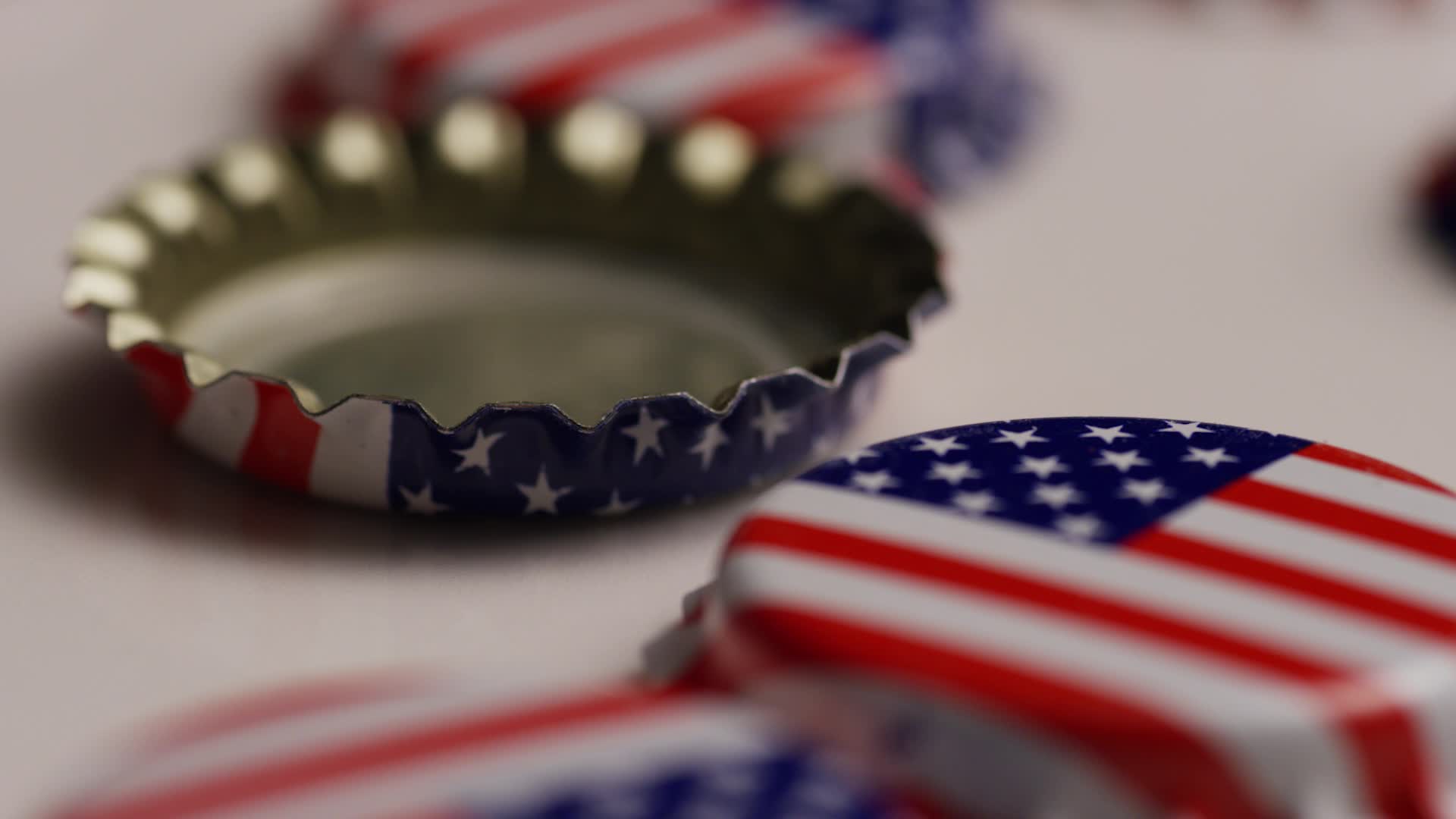 Rotating shot of bottle caps with the American flag printed on them