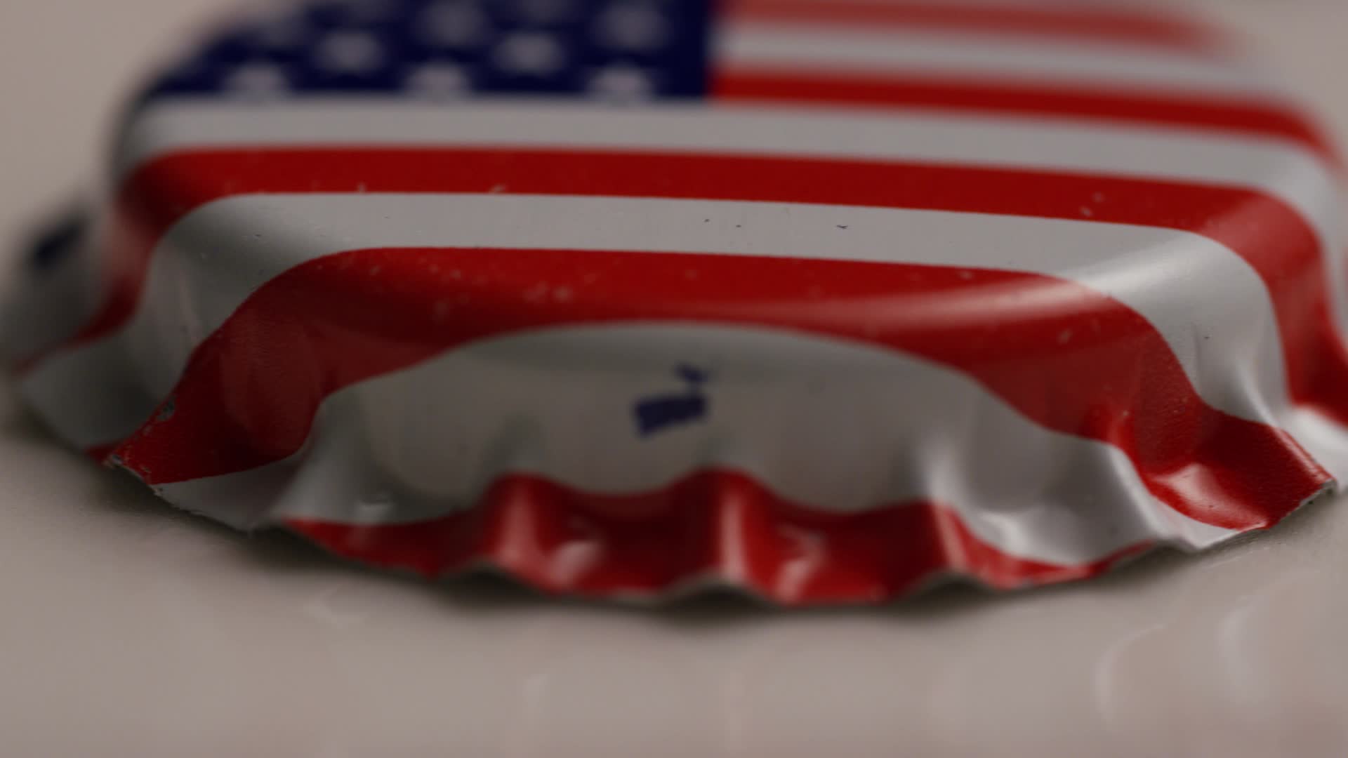 Rotating shot of bottle caps with the American flag printed on them