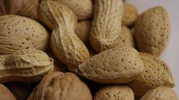 Cinematic, rotating shot of a variety of nuts on a white surface - NUTS MIXED 017 video