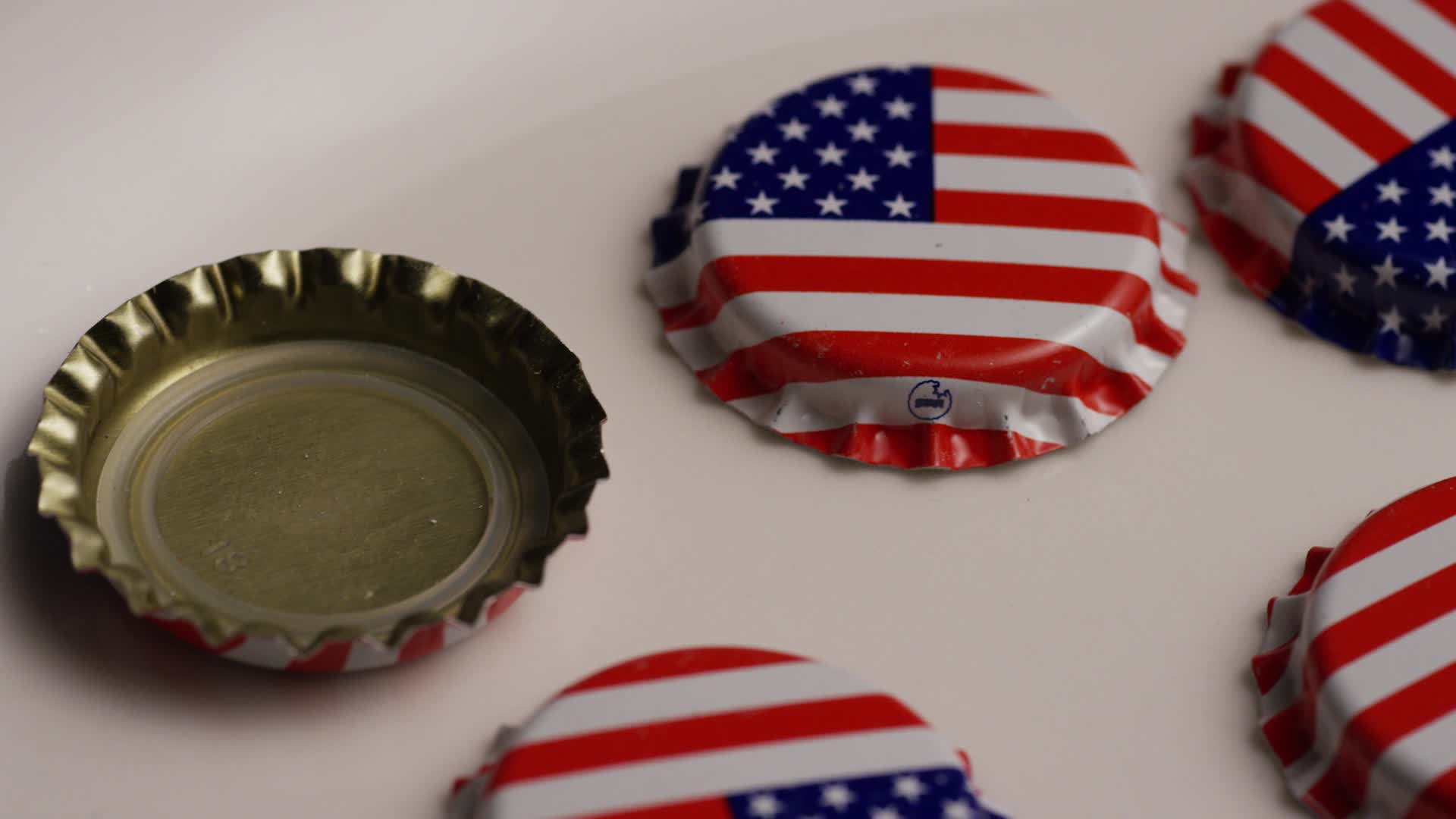 Rotating shot of bottle caps with the American flag printed on them