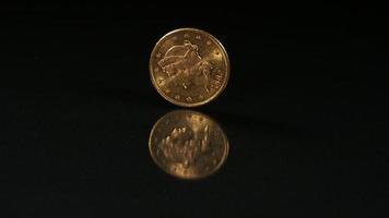 goldene Münze, die sich in Ultra-Zeitlupe (1.500 fps) auf einer reflektierenden Oberfläche dreht - Geldmünzen-Phantom 004 video