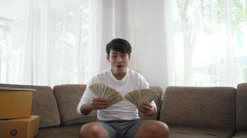 cámara lenta de un joven empresario autónomo disfruta del dinero que recibe de com. el dólar cae desde arriba lentamente. video
