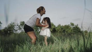 Slow motion of young mother throwing his adorable daughter in the air video