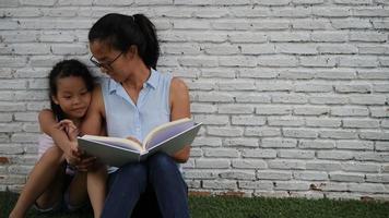 Mother and daughter read funny stories.