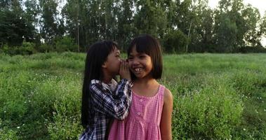 deux petites filles chuchotent en disant des secrets