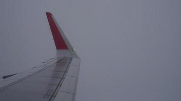 Wing of an airplane flying above the clouds from window plane view video