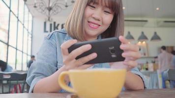 Female blogger photographing green tea cup in cafe with her phone.