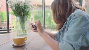 vrouwelijke blogger fotograferen van groene thee beker in café met haar telefoon. video