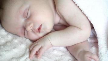 Close up of newborn little baby girl is sleeping on the bed, sweet dreams of little baby, healthy sleep. video