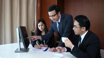 Businessman examining graphs with other coming people. video