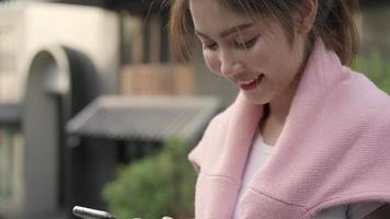 Cheerful Asian backpacker blogger woman using smartphone for direction and looking on location map. video
