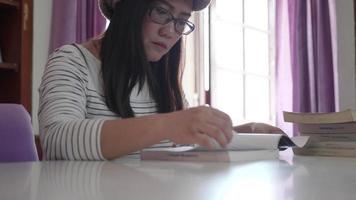 estudiante mujer asiática que estudia en la biblioteca. video