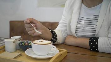 Woman drinking warm coffee enjoying it while sitting in cafe.	 video