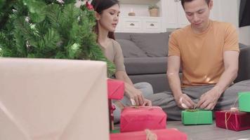 asiatisches Paar, das Weihnachtsgeschenke verpackt video