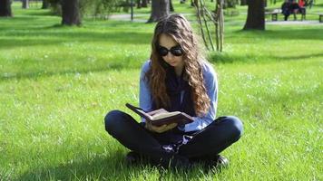 jeune femme lisant dans le parc