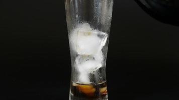 vertiendo soda en un vaso con hielo