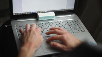 mãos masculinas em um teclado de laptop video