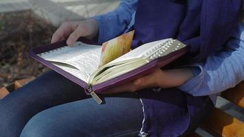 close-up de mãos femininas segurando a Bíblia