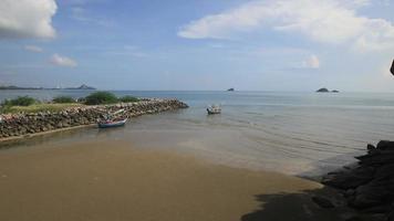 Barco de pesca en la playa con cielo azul en Tailandia. video
