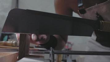 a close-up, A carpenter treats a wooden board with a saw 