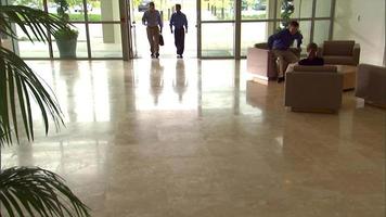 Businessmen walk into entrance doors video