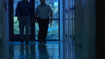 Men walk down dark hallway video