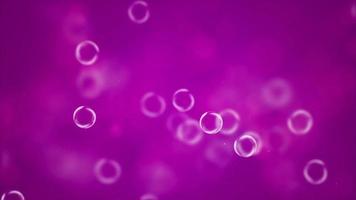 close-up de bolhas transparentes em movimento em fundo rosa