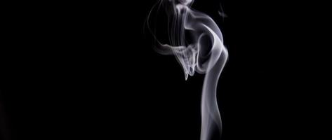 espirais criadas por fumaça branca controlada subindo na escuridão em 4k video